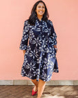 Model wearing navy dress with white floral print.