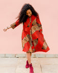 Model wearing red and brown abstract print dress.