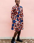 model wearing a colorful geometric shirt dress with a pinwheel design