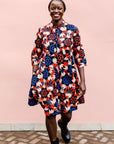 model wearing a colorful geometric shirt dress with a pinwheel design