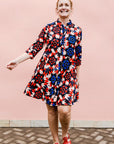 model wearing a colorful geometric shirt dress with a pinwheel design