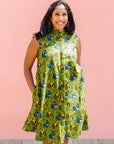 Model wearing green sleeveless dress with blue and yellow bubble design.