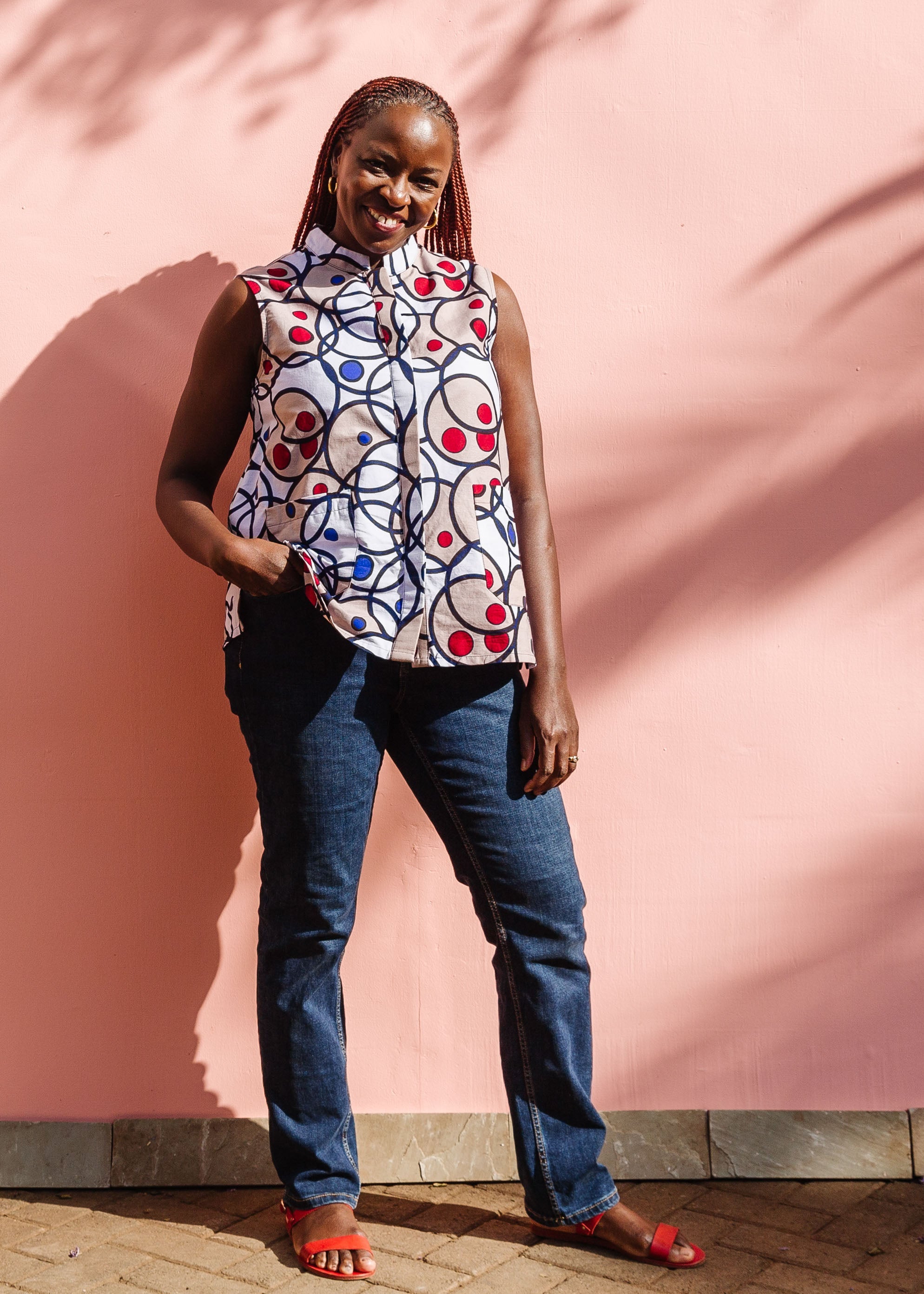 Model wearing white and tan tank top with circle print.