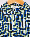 Close up of green, blue, black squiggle print, long sleeved blouse.