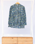 Display of green, blue, black squiggle print, long sleeved blouse.
