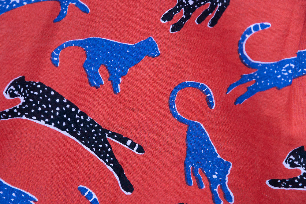 Close up display of red cat print shirt, fabric.