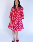 Model wearing red dress with pink flower print.