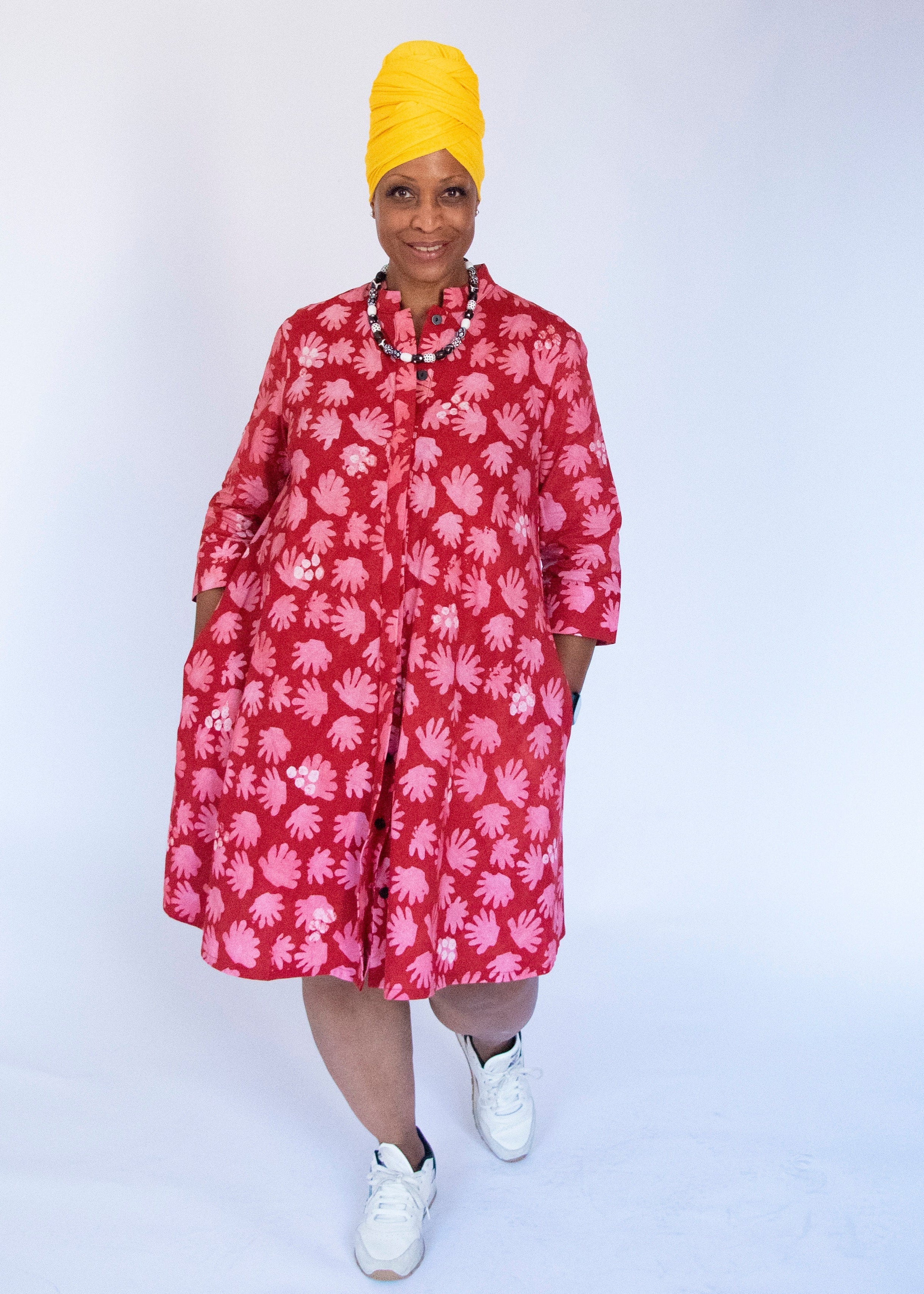 Model wearing red dress with pink flower print.