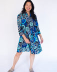 Model wearing dress with blue and grey gear graphic print.