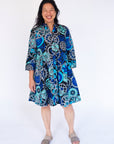 Model wearing dress with blue and grey gear graphic print.