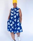 Model wearing blue sleeveless dress with white triangle print.