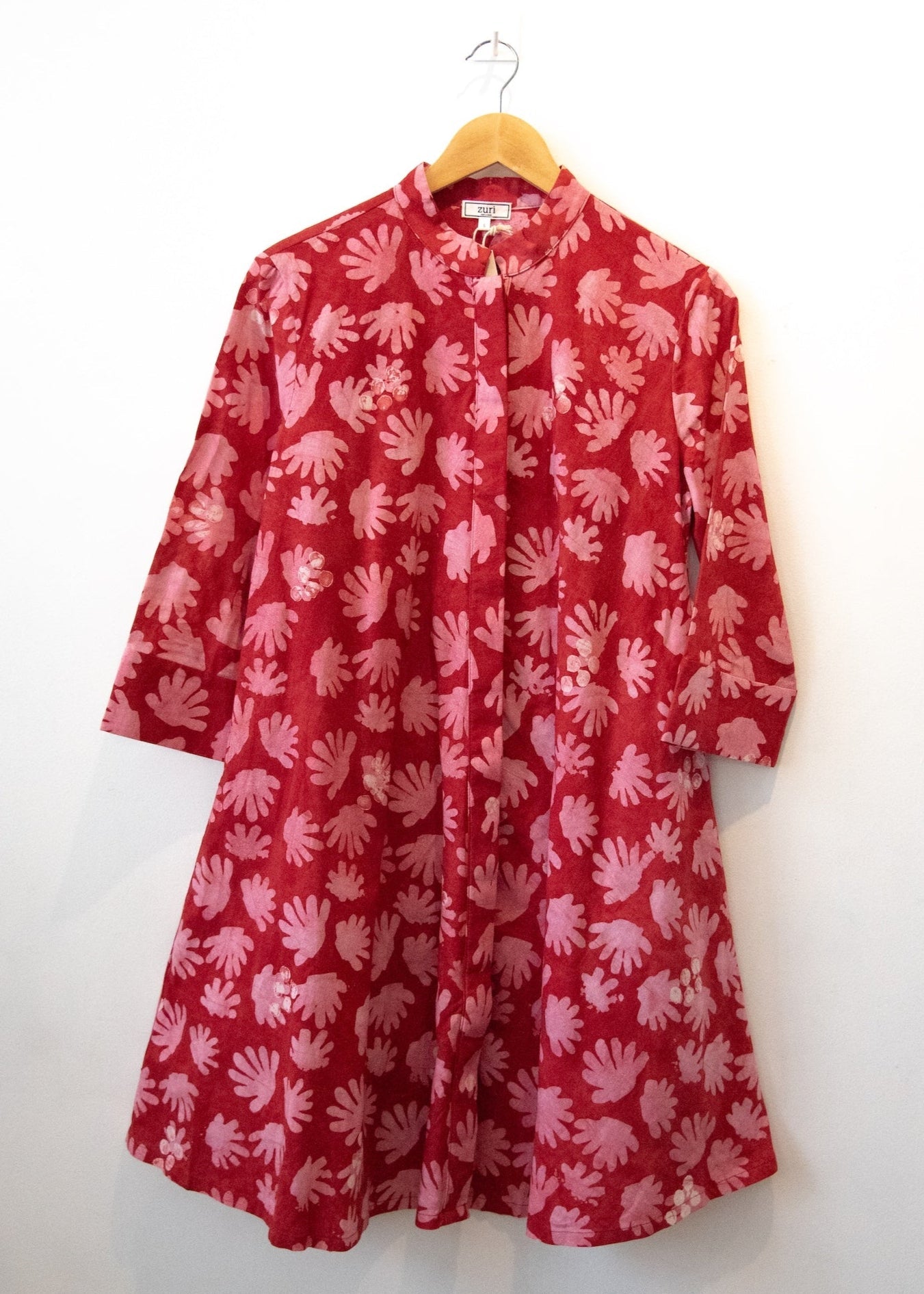 Display of red dress with pink flowers.