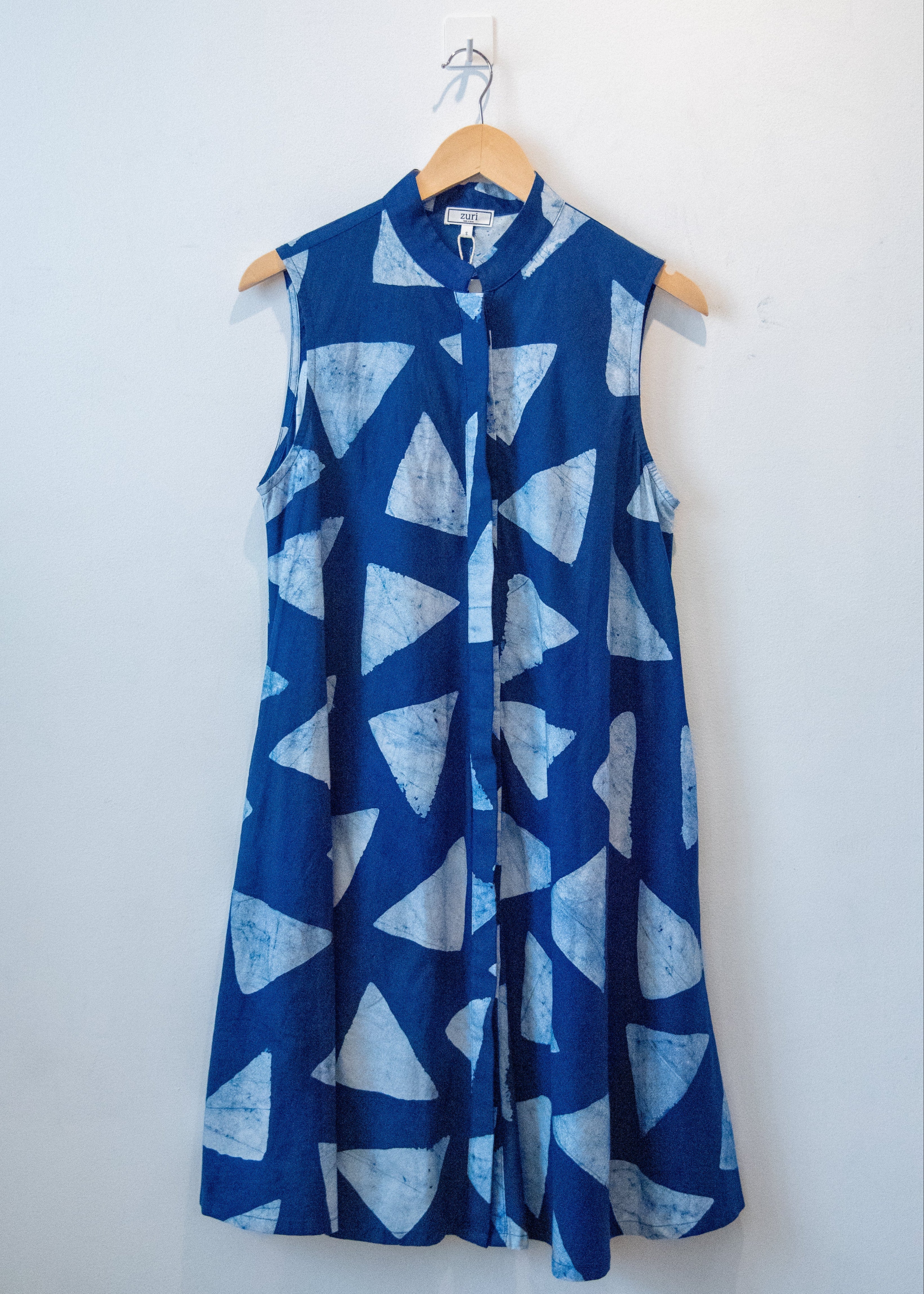 Display of blue sleeveless dress with white triangle print.