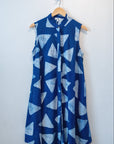 Display of blue sleeveless dress with white triangle print.