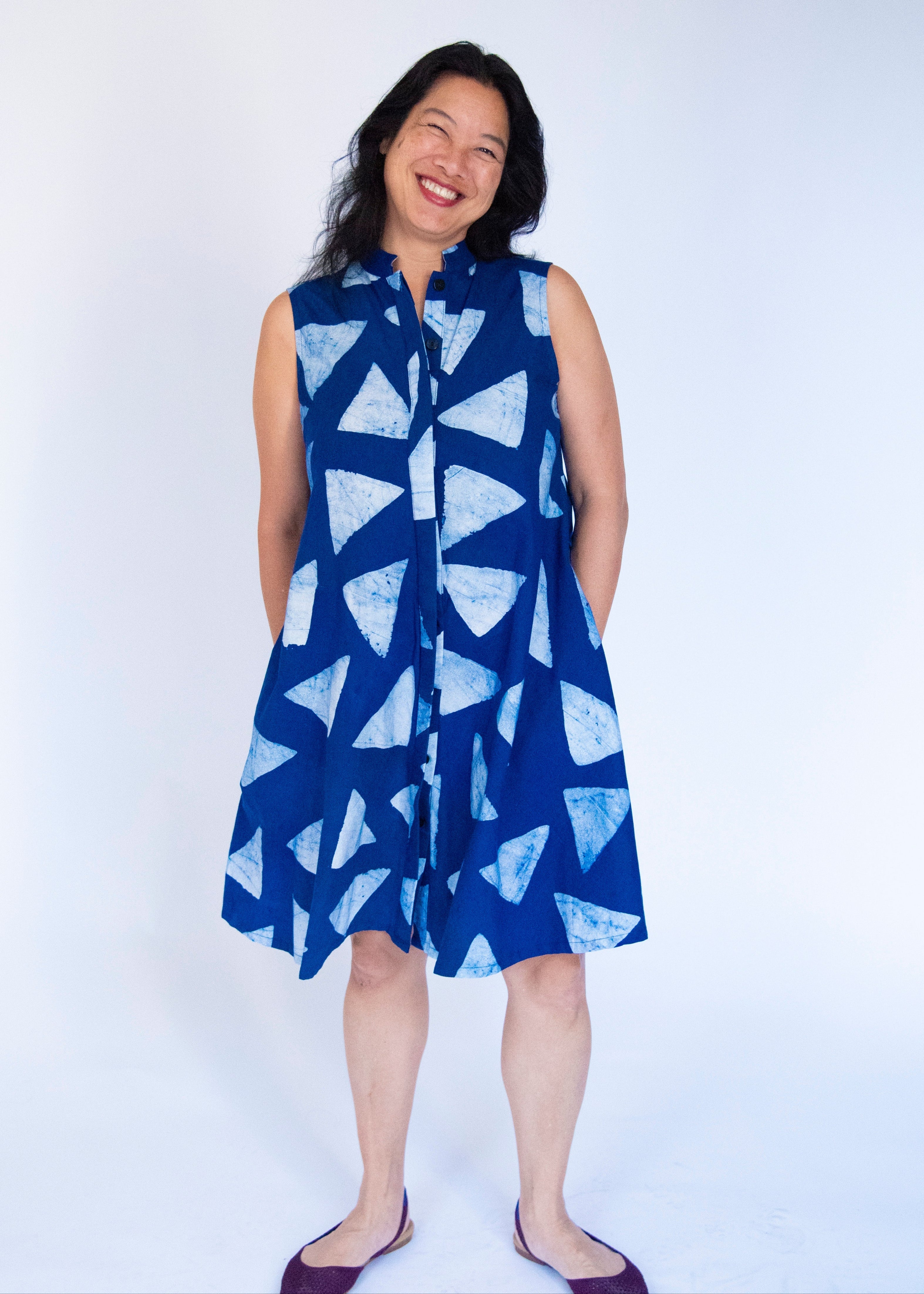 Model wearing blue sleeveless dress with white triangle print.