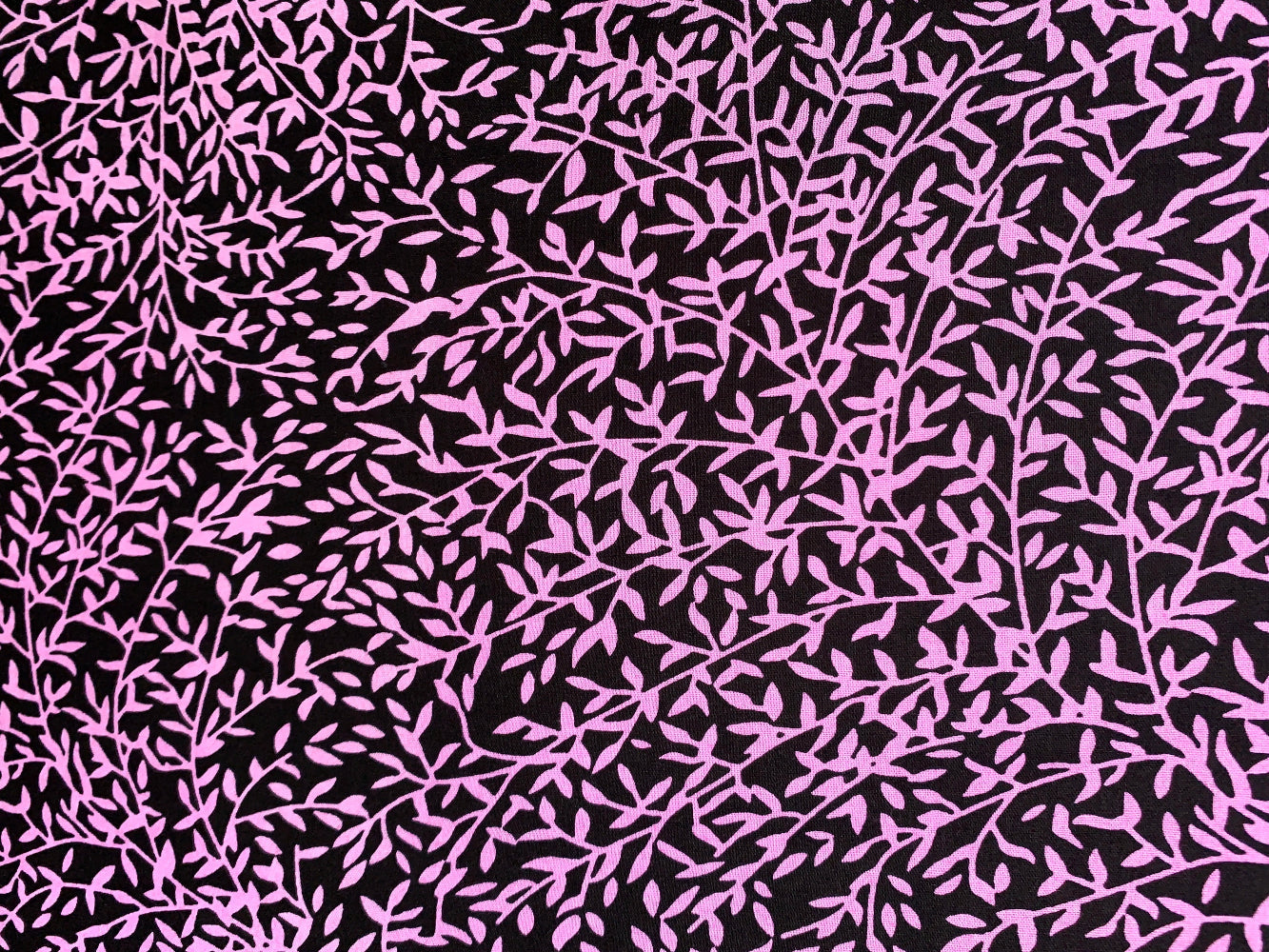 Close up display of black and purple floral print sleeveless shirt, fabric.
