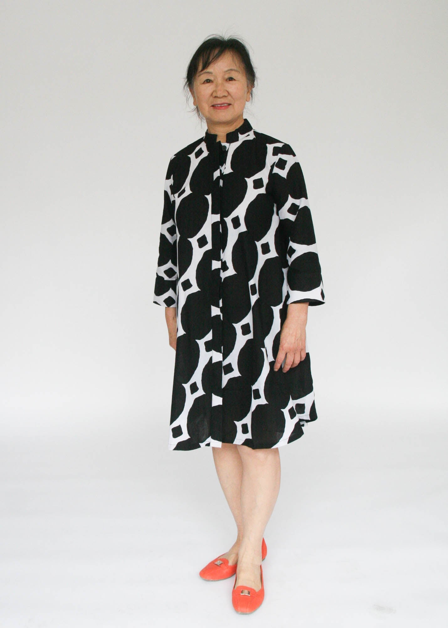 Model wearing black and white geometric print dress.
