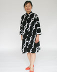 Model wearing black and white geometric print dress.