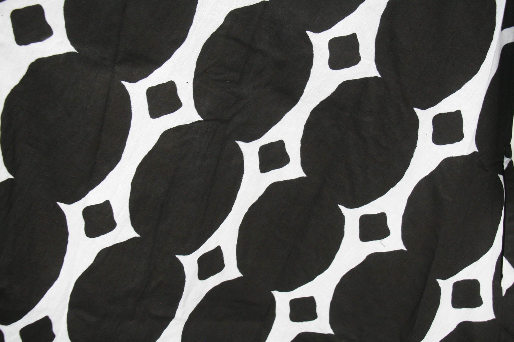 Close up display of black and white geometric print dress, fabric.