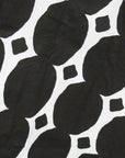 Close up display of black and white geometric print dress, fabric.