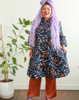 model wearing floral and leaf print navy dress 