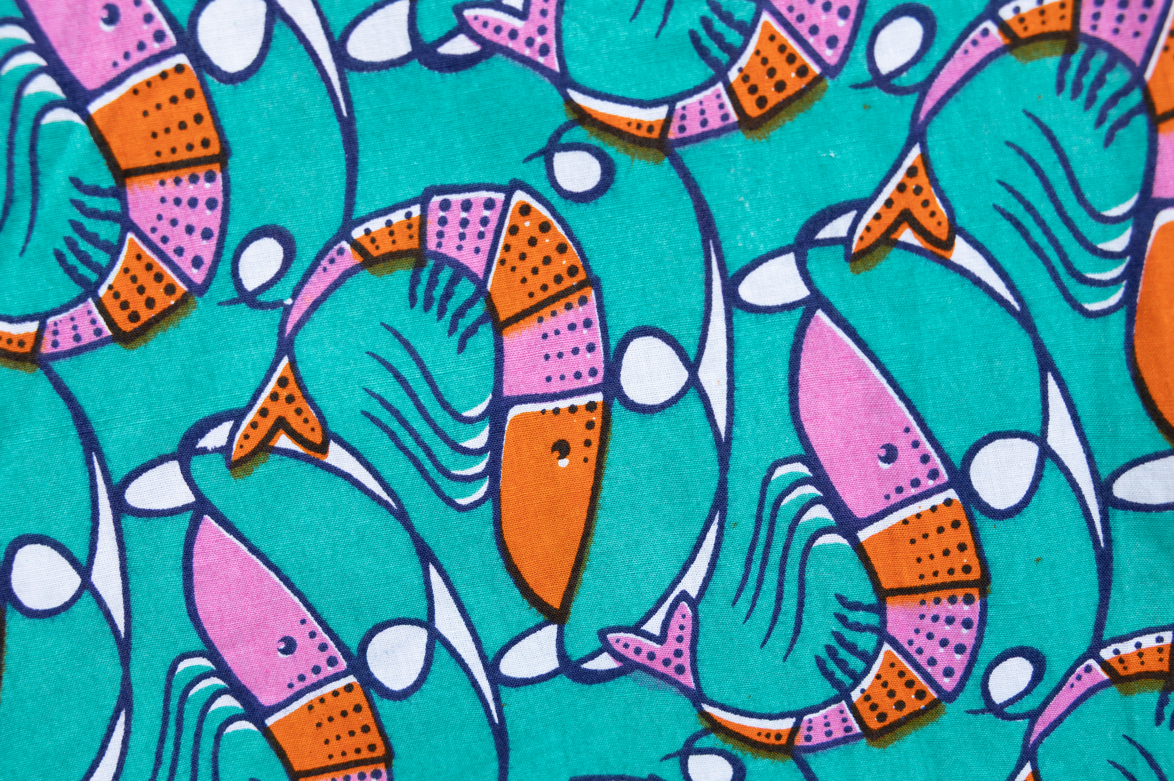 Close up display of teal dress with pink and orange shrimp print, fabric.