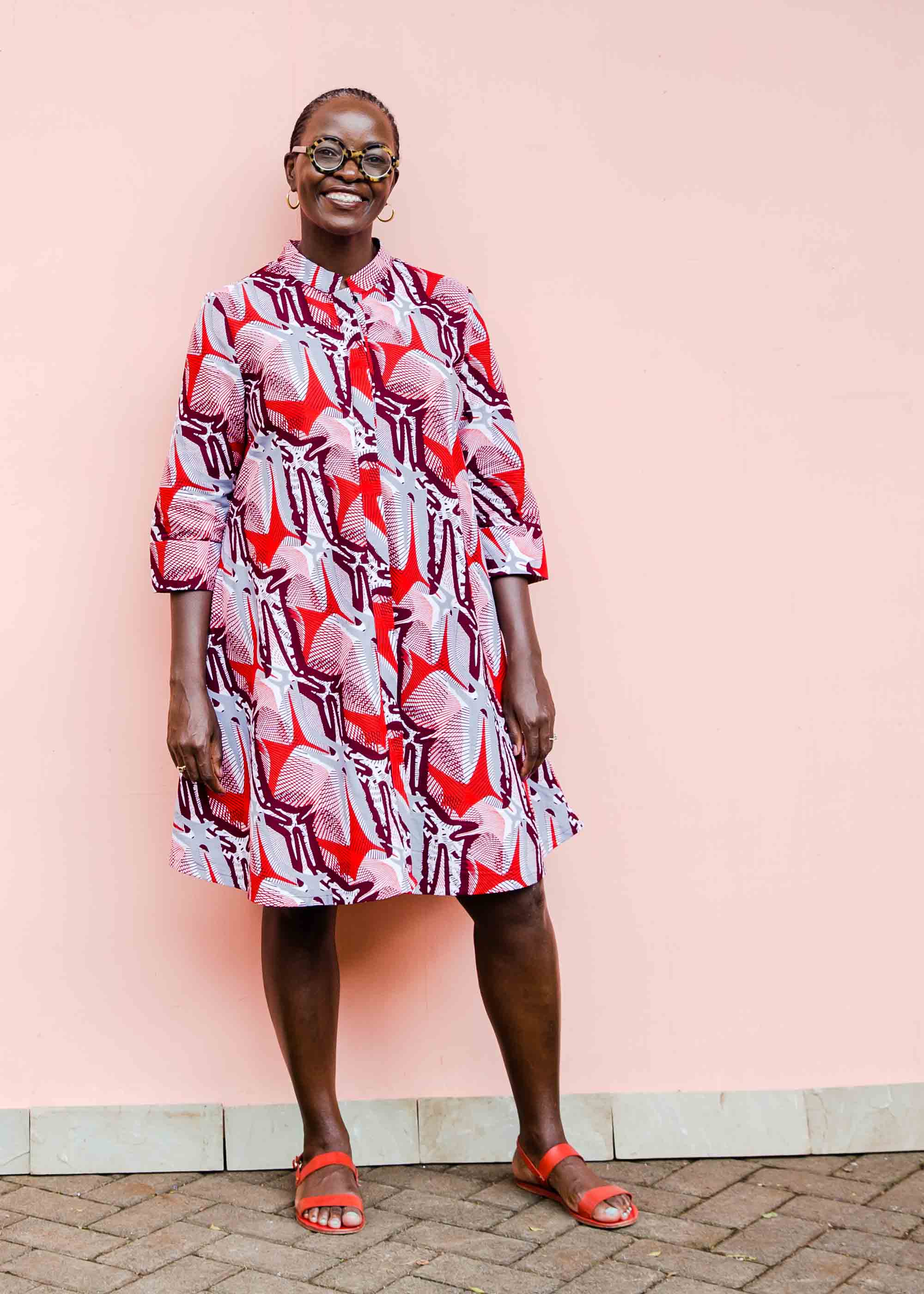 Model wearing a red, grey and maroon geometric shirt dress