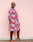 Model wearing a red, grey and maroon geometric shirt dress