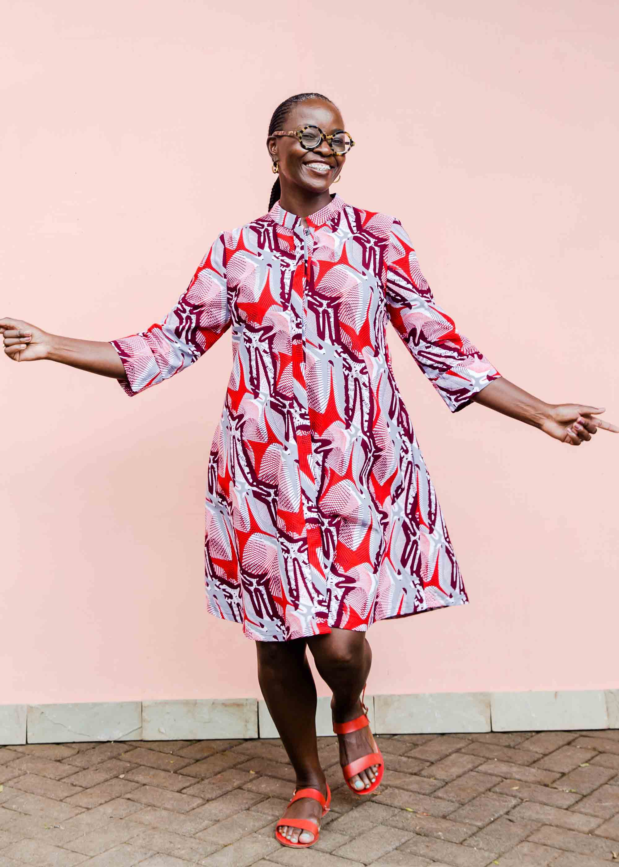 Model wearing a red, grey and maroon geometric shirt dress