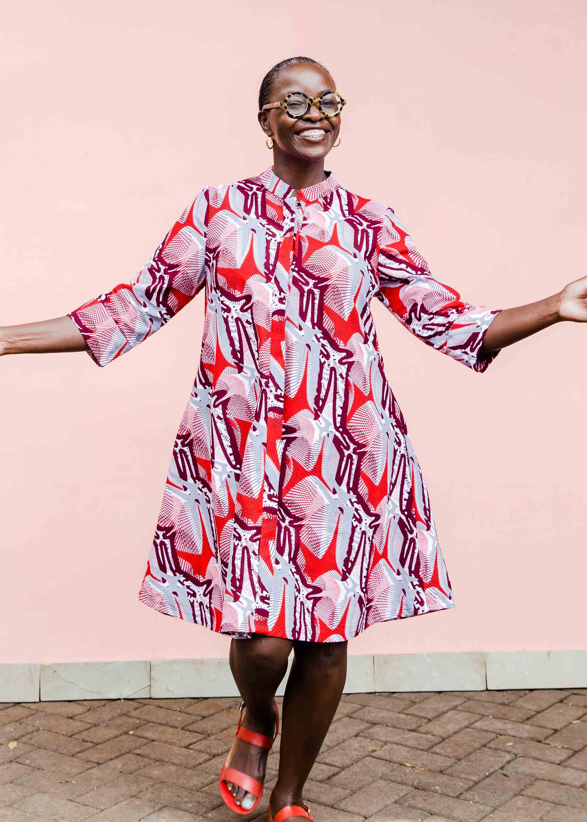 Model wearing a red, grey and maroon geometric shirt dress