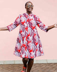 Model wearing a red, grey and maroon geometric shirt dress