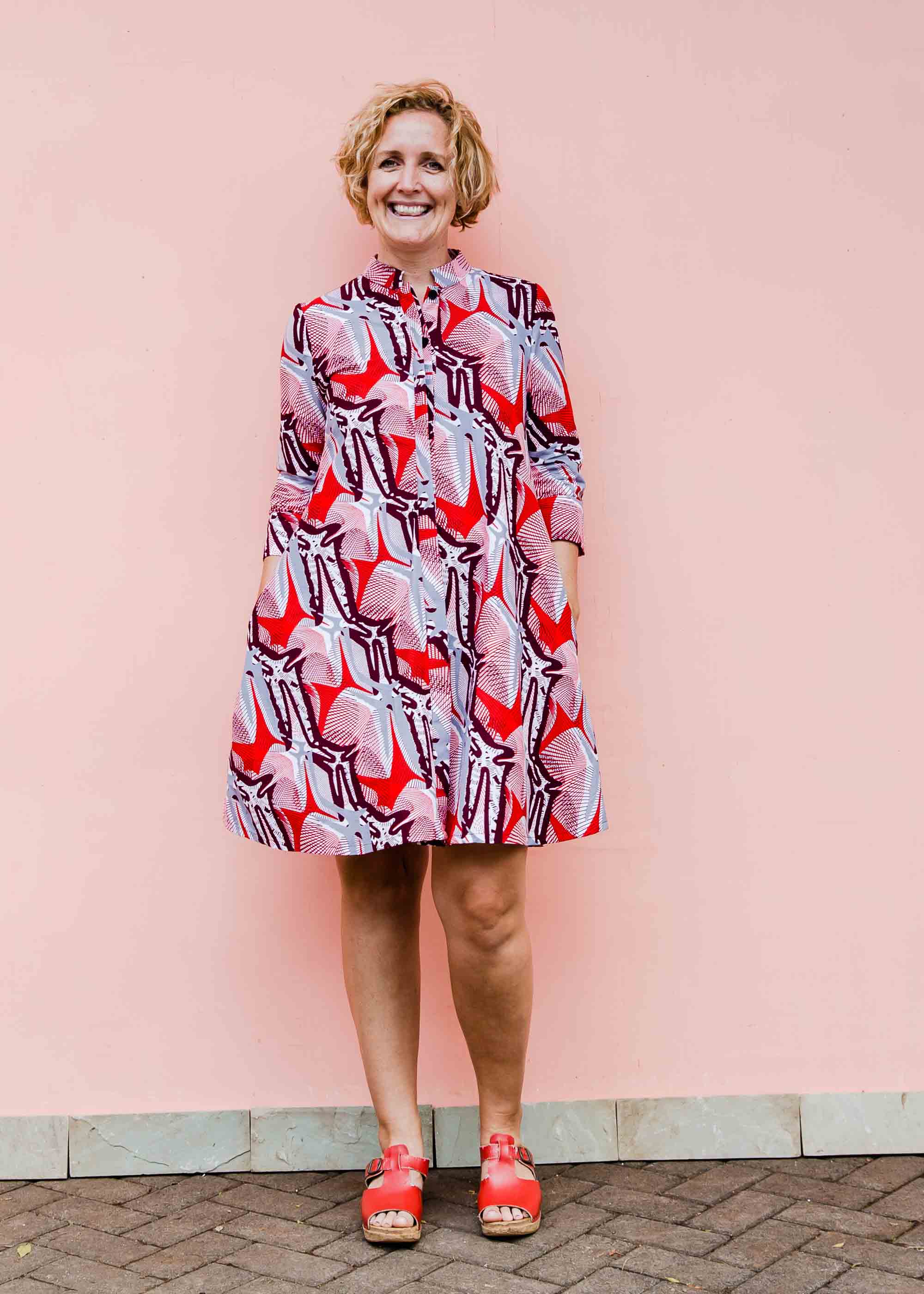 Model wearing a red, grey and maroon geometric shirt dress