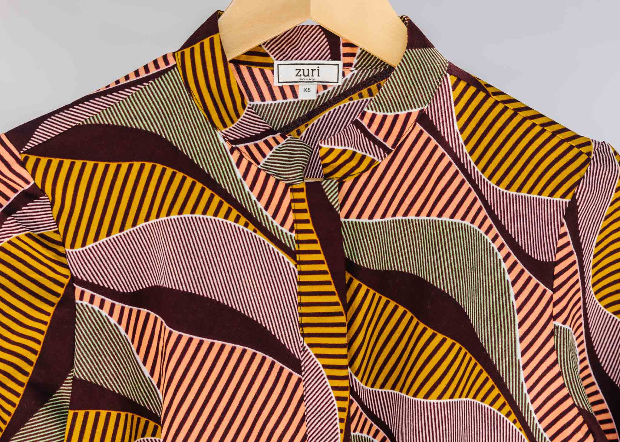 Display of neutral color geometric print dress.