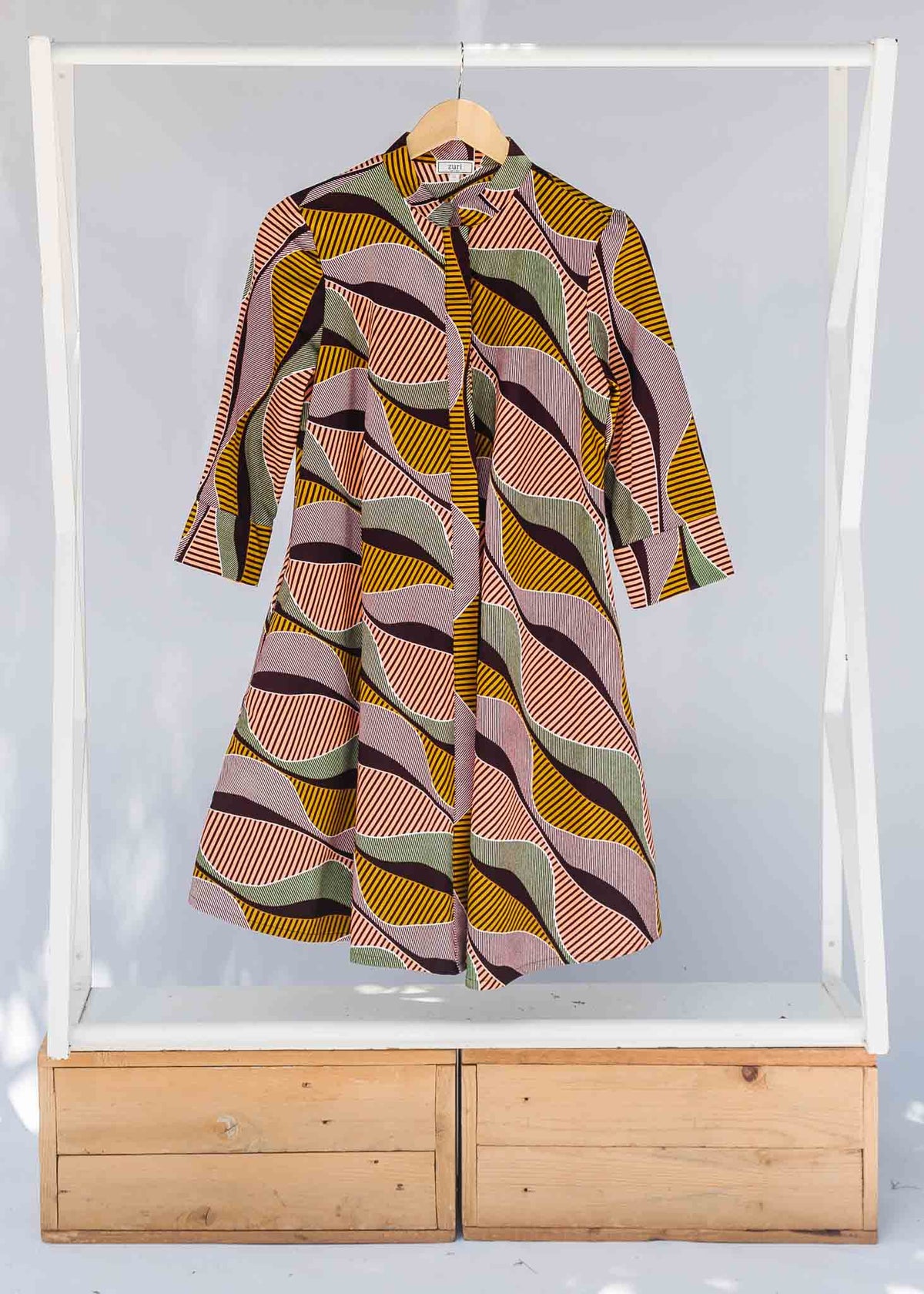 Display of neutral color geometric print dress.