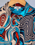 Display of beige, orange, navy and aqua, abstract print dress.