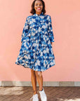 Model wearing blue and white floral print dress.