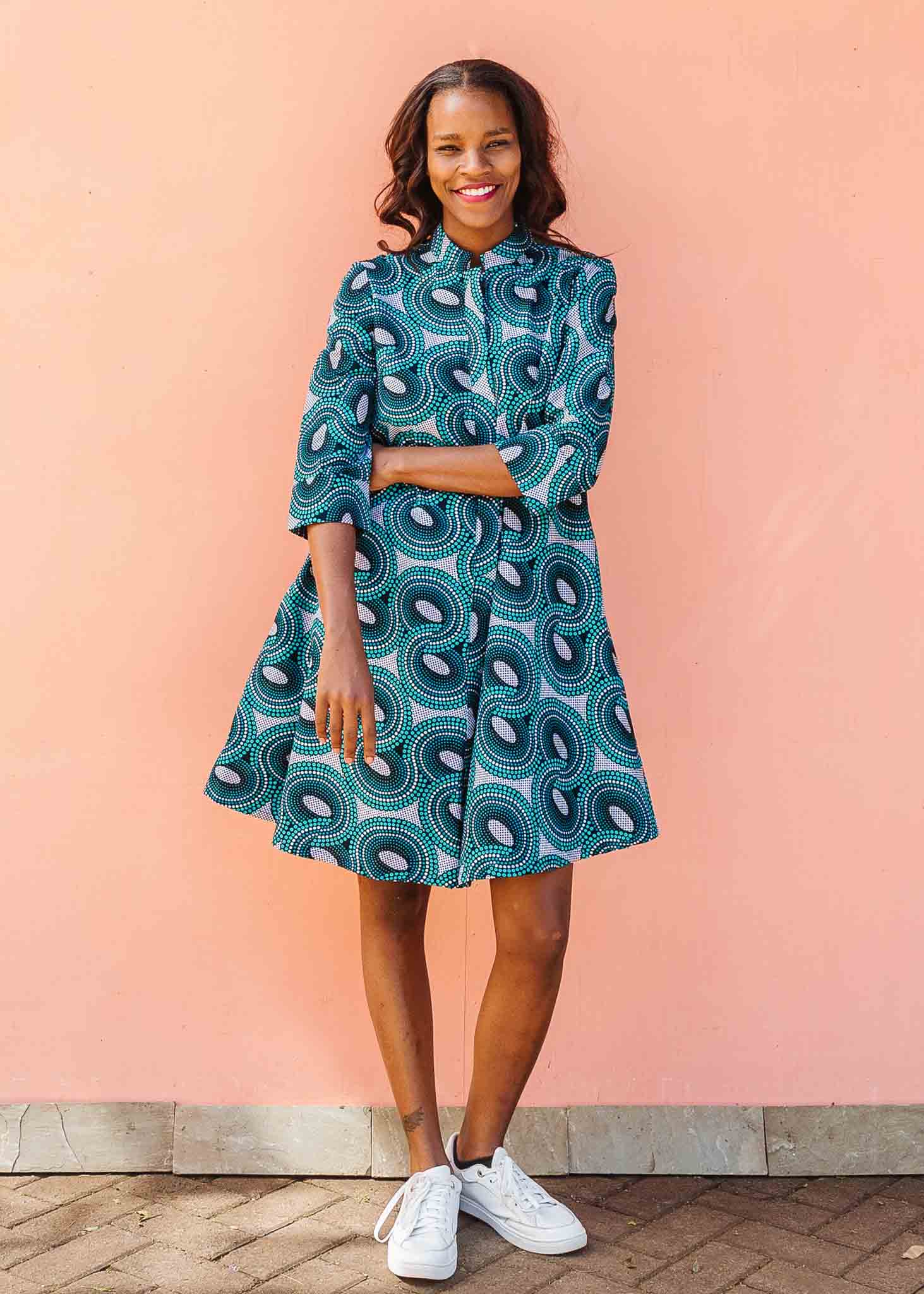 Model wearing dress with teal shaded loop print.