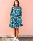 Model wearing dress with teal shaded loop print.