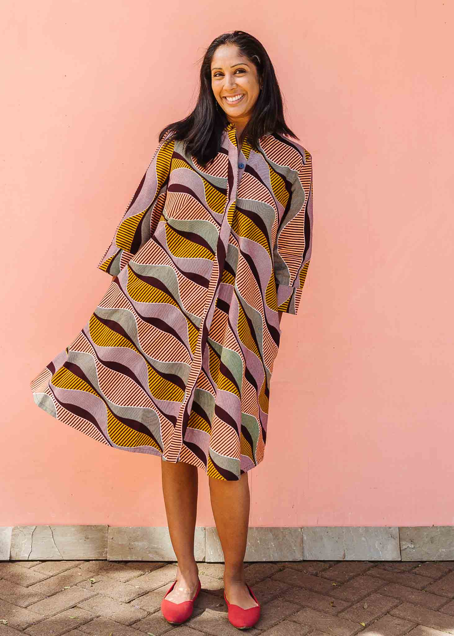 Model wearing neutral color geometric print dress.