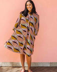 Model wearing neutral color geometric print dress.