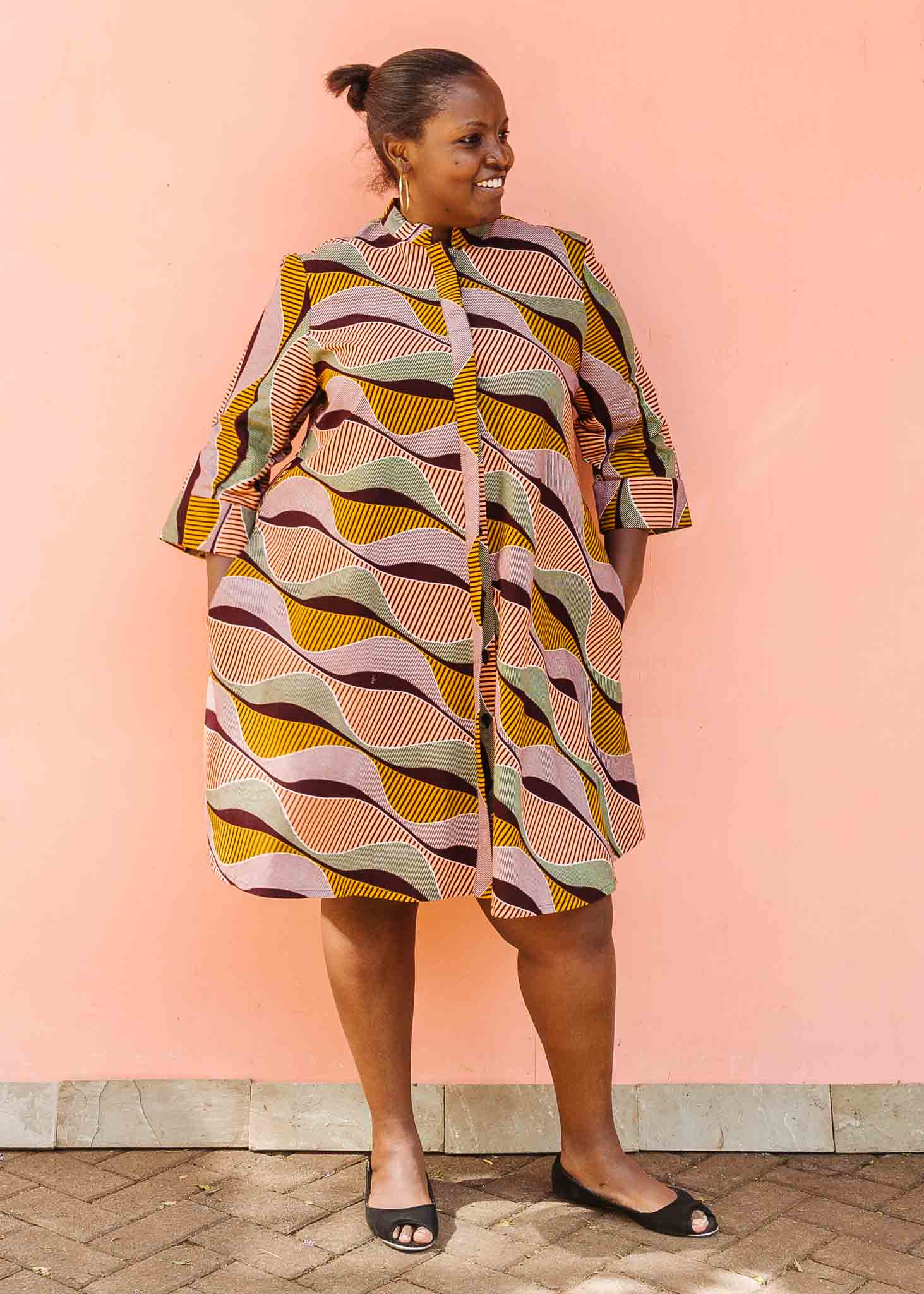 Model wearing neutral color geometric print dress.