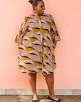 Model wearing neutral color geometric print dress.