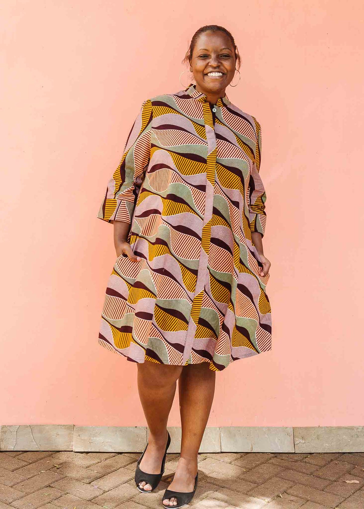 Model wearing neutral color geometric print dress.