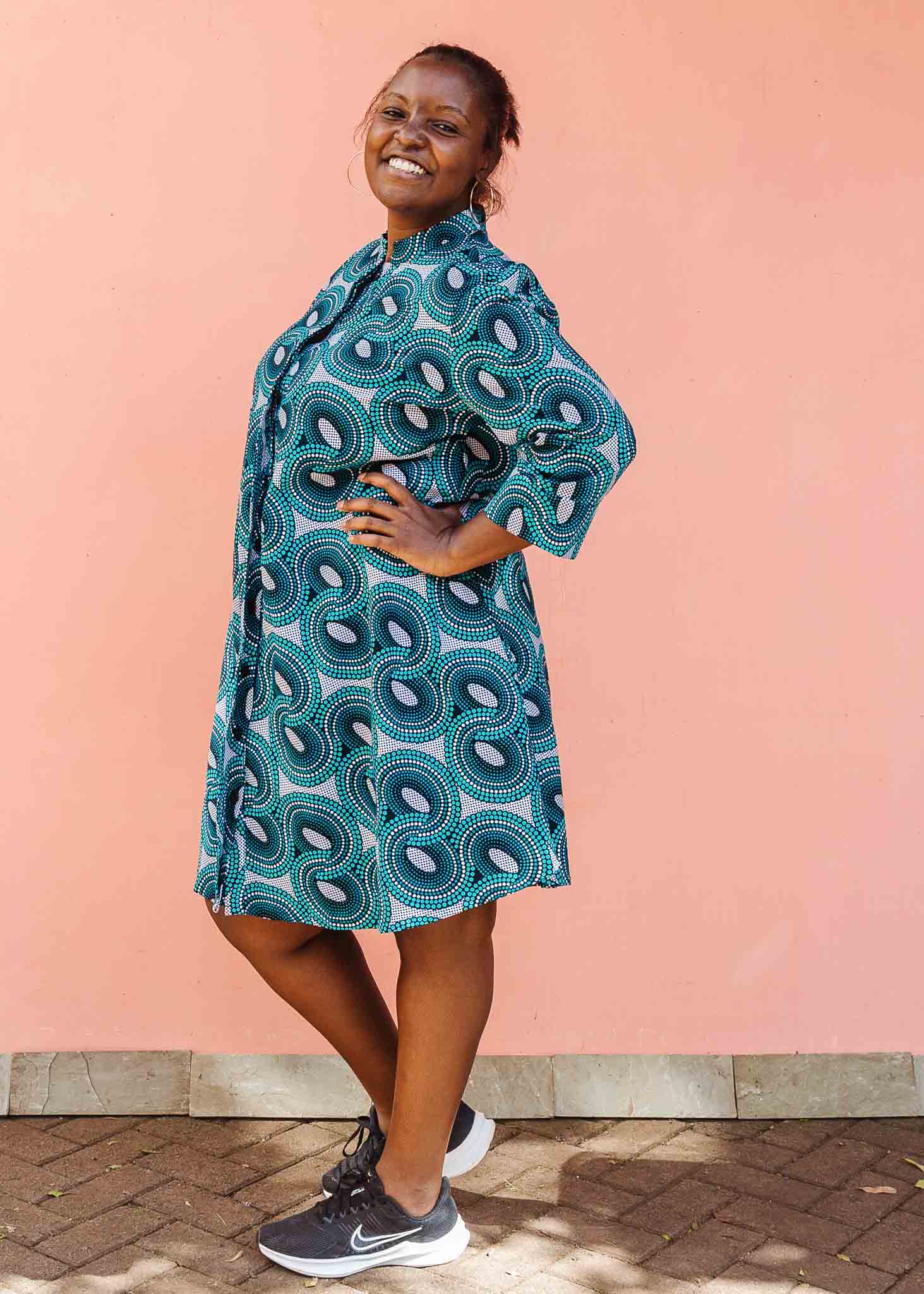 Model wearing dress with teal shaded loop print.