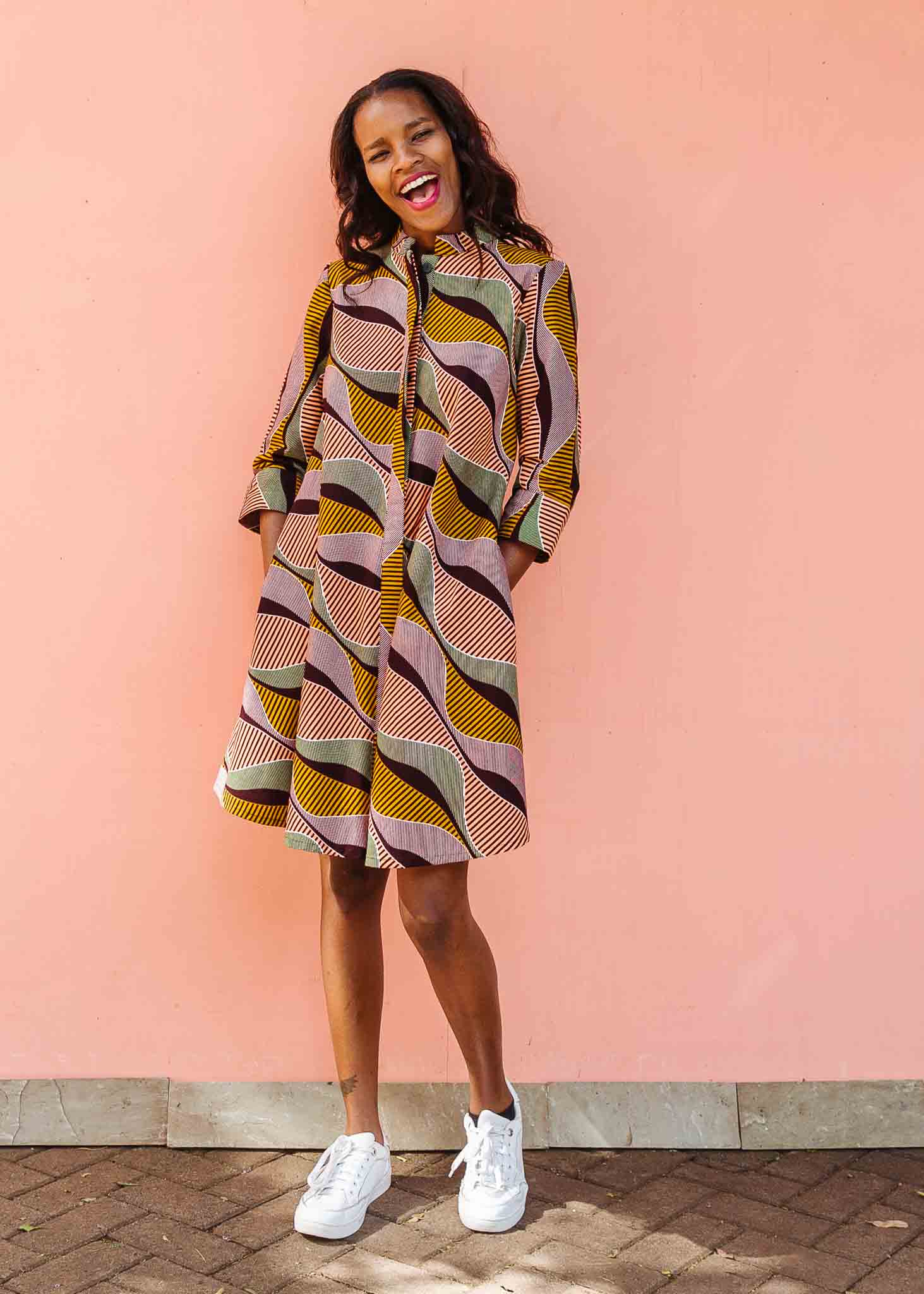 Model wearing neutral color geometric print dress.