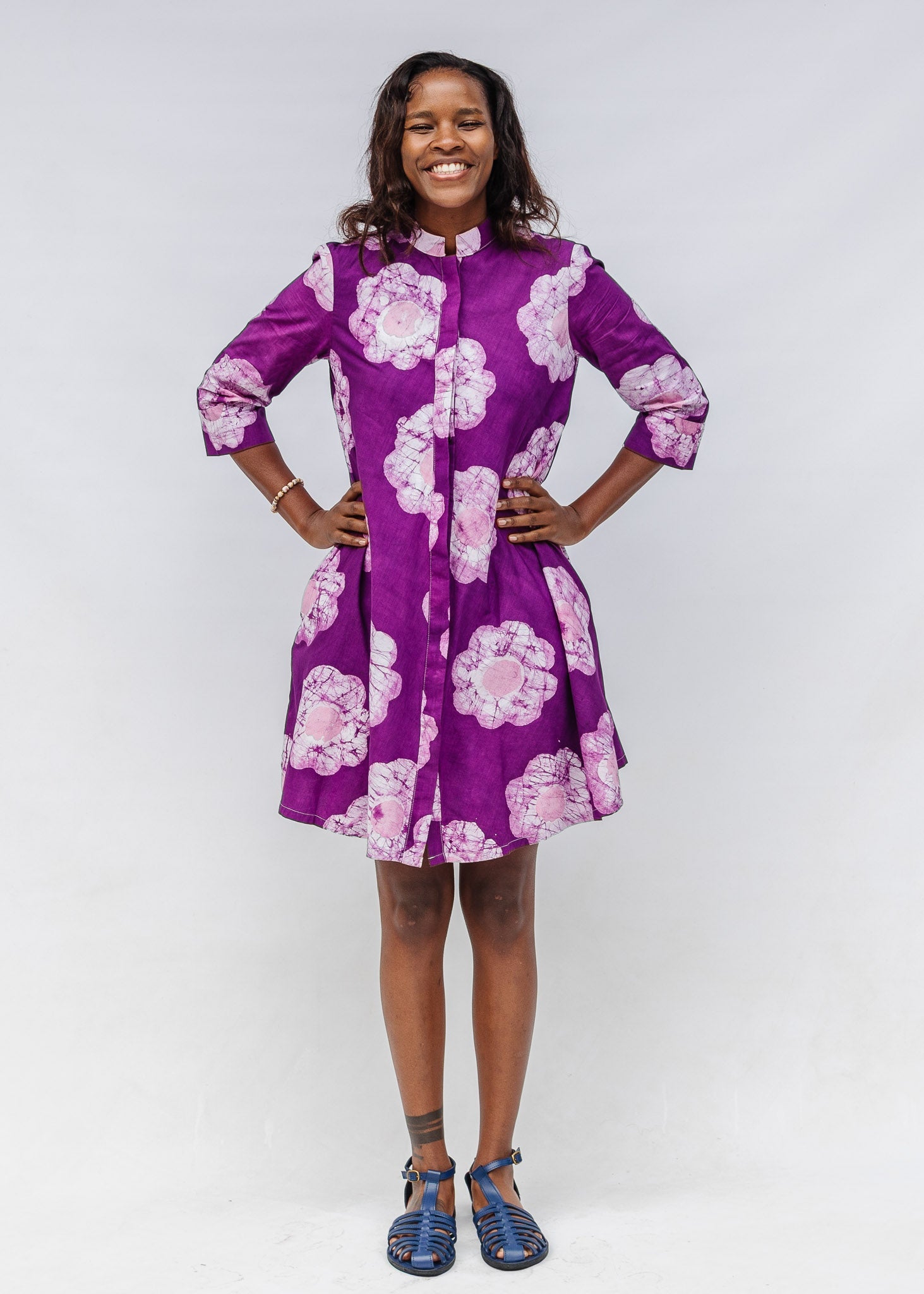 Woman wearing a purple floral dress against a white background