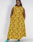 Model wearing yellow dress with black and white paisley print.