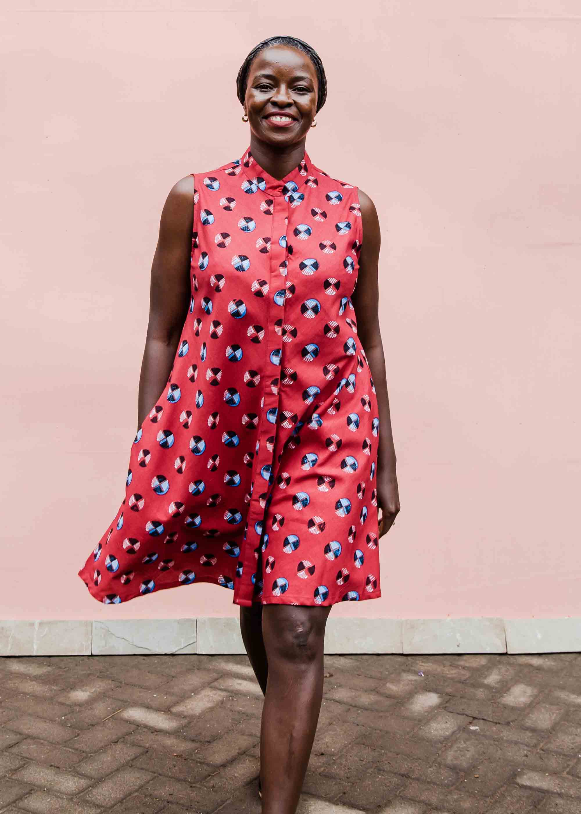 model wearing a sleeveless dress with a red, blue, white and black design