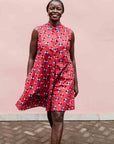 model wearing a sleeveless dress with a red, blue, white and black design