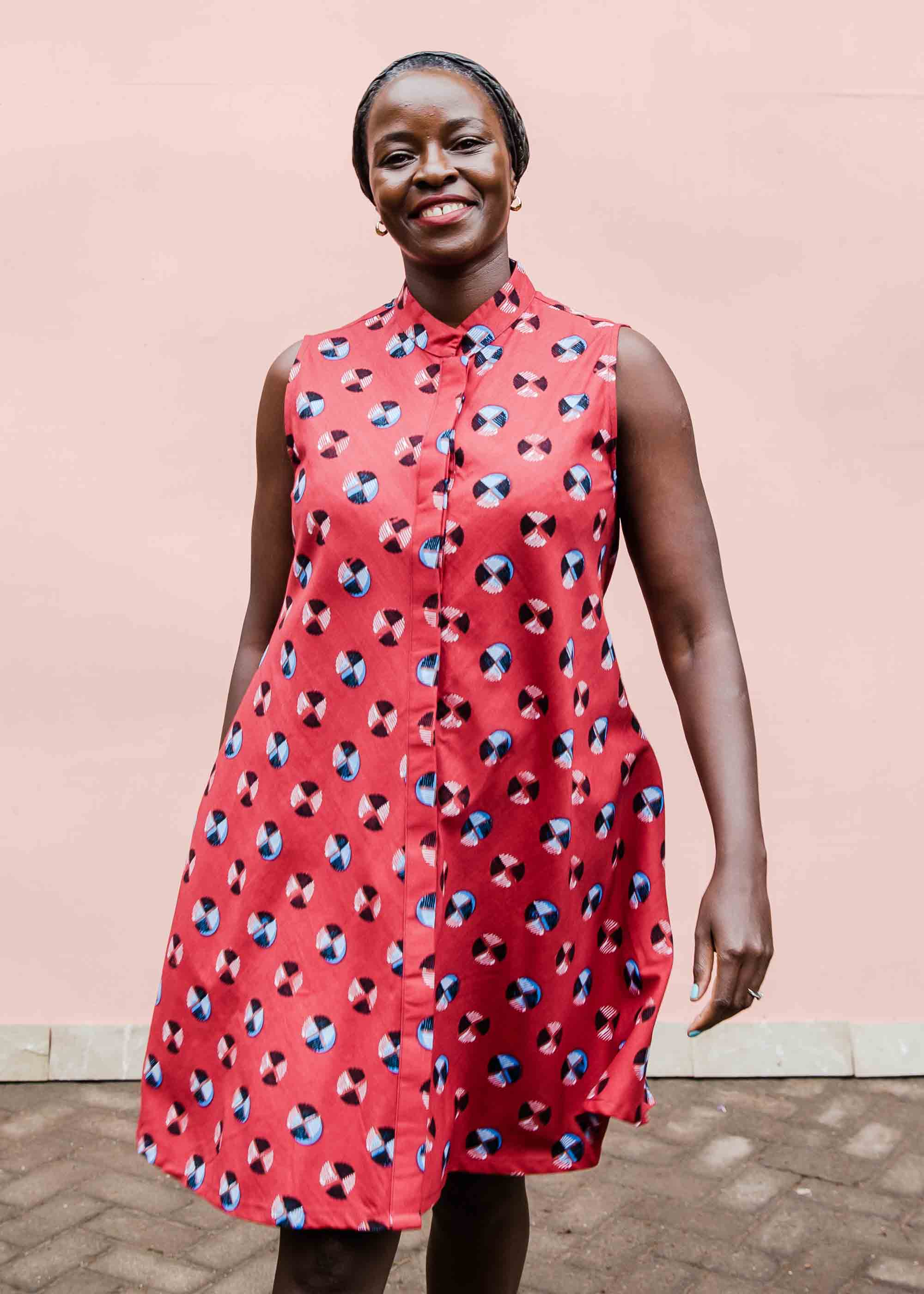 model wearing a sleeveless dress with a red, blue, white and black design